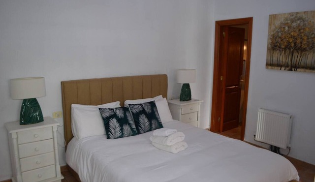 This is a double room with a double bed. It has an en-suite bathroom. The window in the room looks out into the hallway. in Vilaflor