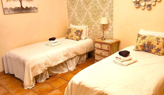 This room has two single beds with an en-suite bathroom. The room looks onto the road and has mountain views to the rear of the building. in Vilaflor